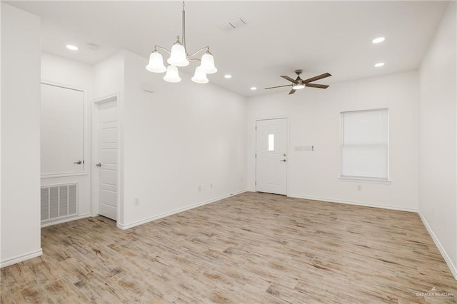 unfurnished room featuring ceiling fan with notable chandelier and light wood-type flooring