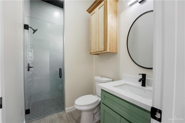 full bath with a stall shower, vanity, and toilet