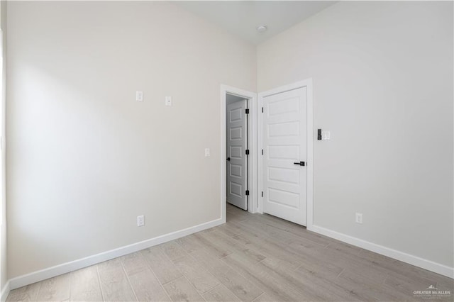 empty room featuring light wood-style flooring and baseboards