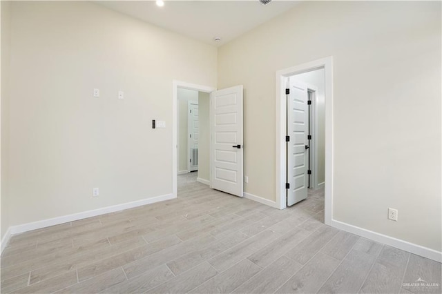 unfurnished bedroom featuring light wood finished floors and baseboards