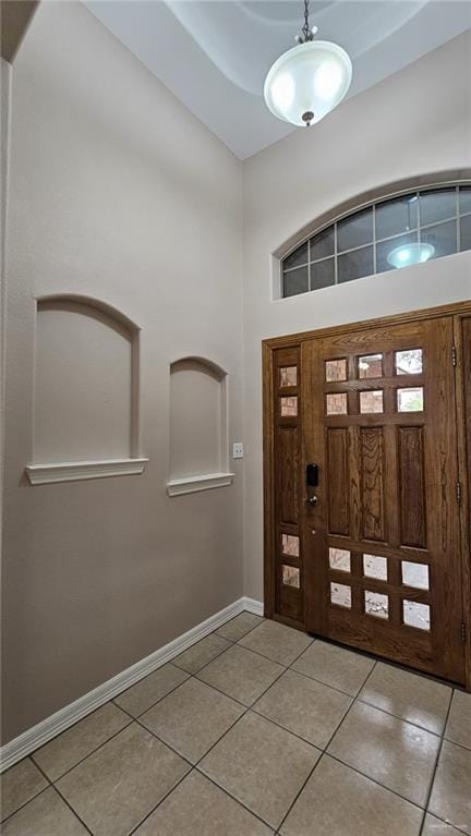 tiled entrance foyer with a towering ceiling