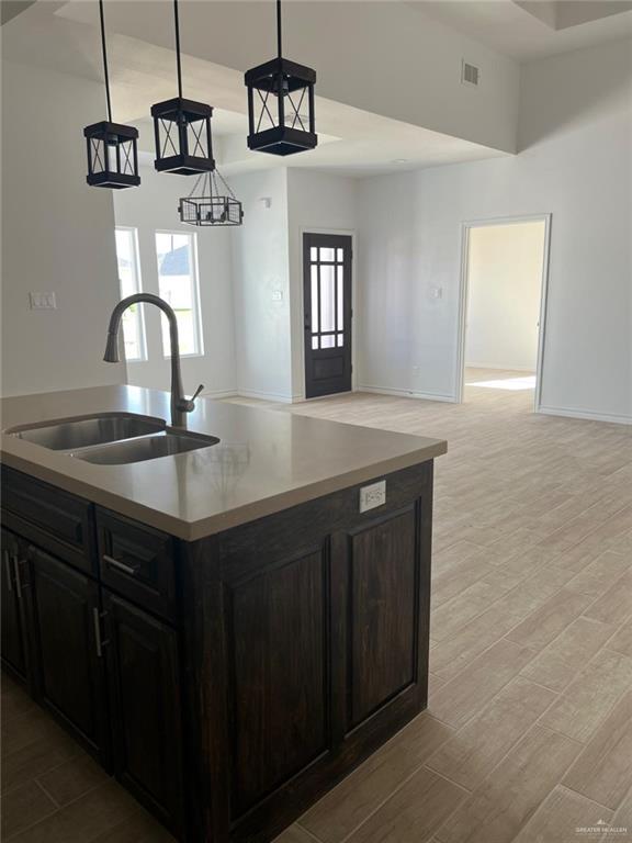 kitchen with sink, light hardwood / wood-style floors, and decorative light fixtures