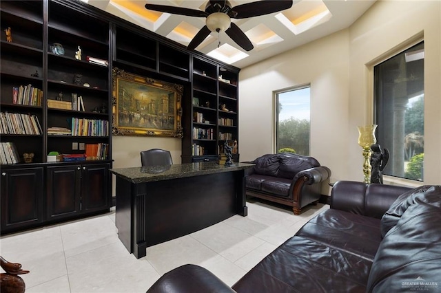 office area with light tile patterned floors, ceiling fan, coffered ceiling, and a healthy amount of sunlight