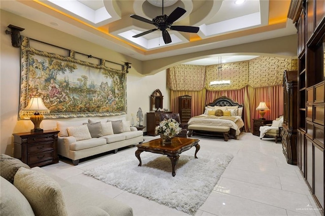 interior space with ceiling fan with notable chandelier, light tile patterned flooring, and coffered ceiling