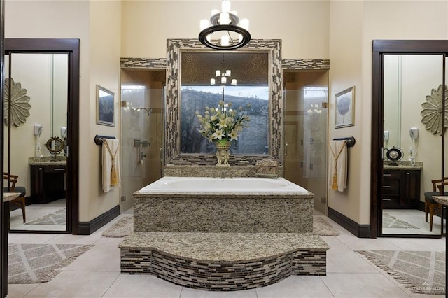 bathroom featuring vanity, a shower stall, a bath, tile patterned floors, and an inviting chandelier