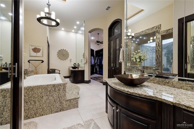 bathroom with a garden tub, vanity, visible vents, and tile patterned floors