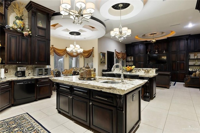 kitchen featuring a chandelier, a sink, hanging light fixtures, dishwasher, and an island with sink