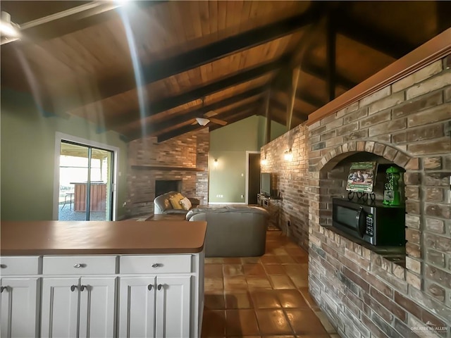 kitchen with white cabinetry, dark tile patterned floors, wood ceiling, and vaulted ceiling with beams