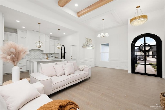 1920 Lime St, San Juan, TX 78589 - living room with a chandelier, arched walkways, light wood-style flooring, beamed ceiling, and recessed lighting
