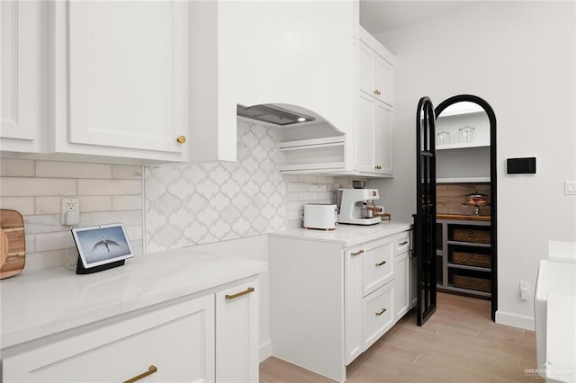 1920 Lime St, San Juan, TX 78589 - kitchen with light wood-type flooring, white cabinets, and backsplash