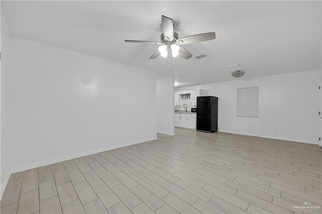 unfurnished living room featuring sink and ceiling fan