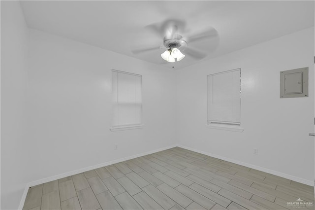 spare room with light wood-type flooring, electric panel, and ceiling fan