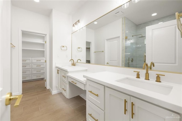 820 N Trinity St, Edinburg, TX 78541 - bathroom with a stall shower, double vanity, wood finished floors, a spacious closet, and recessed lighting