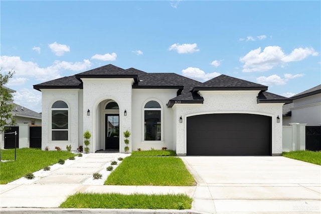 820 N Trinity St, Edinburg, TX 78541 - french country style house with a garage, driveway, a shingled roof, and stucco siding
