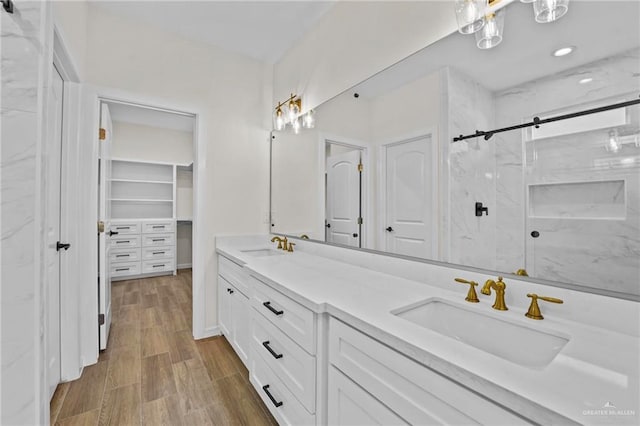 bathroom featuring wood-type flooring, vanity, and a shower with shower door