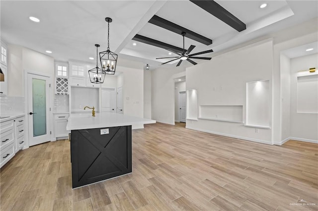 kitchen with a center island with sink, white cabinets, and light hardwood / wood-style floors