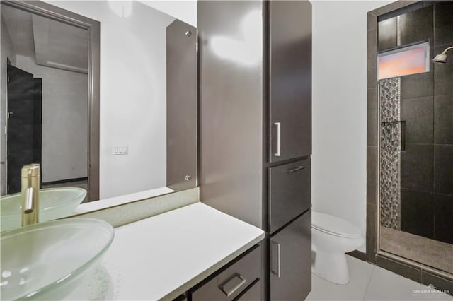 bathroom featuring toilet, tile patterned flooring, walk in shower, and vanity