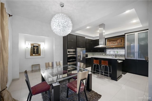 tiled dining area with sink, a raised ceiling, and a notable chandelier