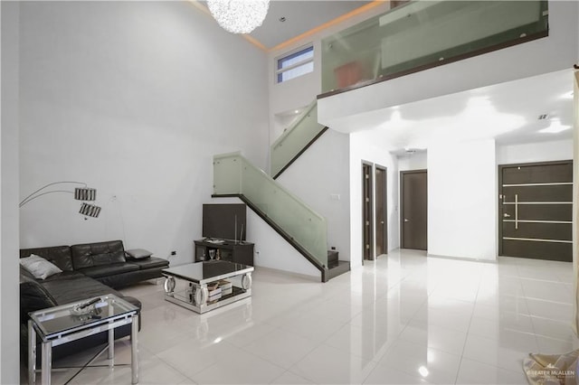 tiled living room with a high ceiling and an inviting chandelier