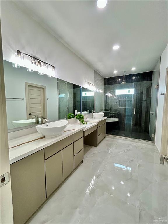 514 Oriole Dr, Los Fresnos, TX 78566 - bathroom featuring a shower stall, marble finish flooring, two vanities, and recessed lighting