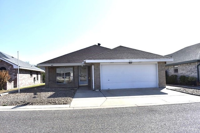 single story home featuring an attached garage, driveway, and a shingled roof