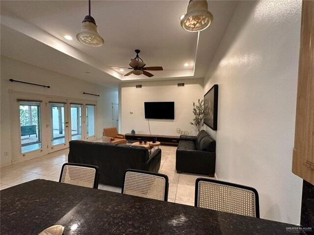 interior space featuring recessed lighting, light tile patterned floors, a raised ceiling, a ceiling fan, and french doors