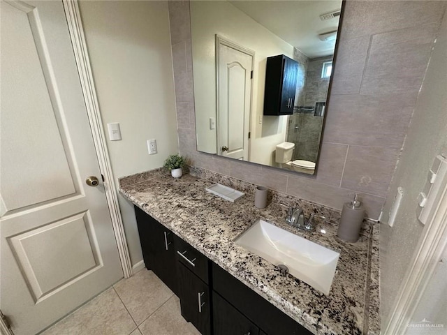 bathroom with a stall shower, tile patterned flooring, and vanity