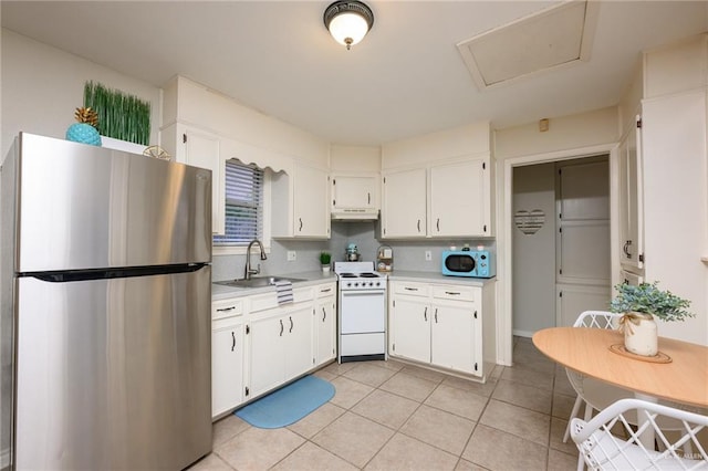2405 E Lazy Lake Dr, Harlingen, TX 78550 - kitchen with white appliances, light countertops, white cabinetry, and light tile patterned flooring
