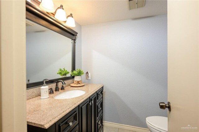 2405 E Lazy Lake Dr, Harlingen, TX 78550 - half bathroom with vanity, toilet, and baseboards