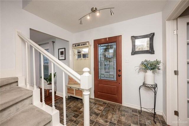 2405 E Lazy Lake Dr, Harlingen, TX 78550 - foyer featuring stairs, stone finish flooring, and baseboards
