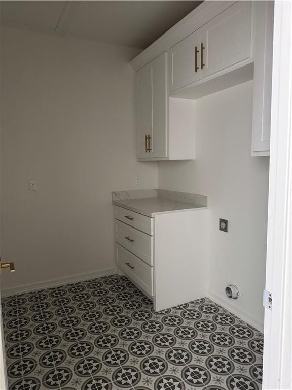 washroom with hookup for an electric dryer and light tile patterned flooring