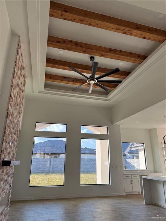 room details with ceiling fan, beamed ceiling, and hardwood / wood-style flooring