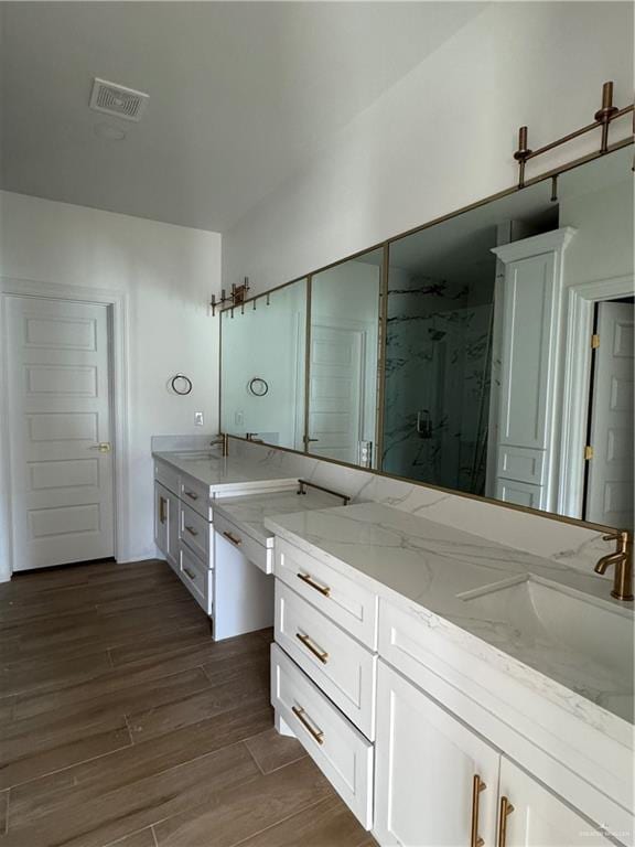 bathroom featuring walk in shower, vanity, and hardwood / wood-style flooring