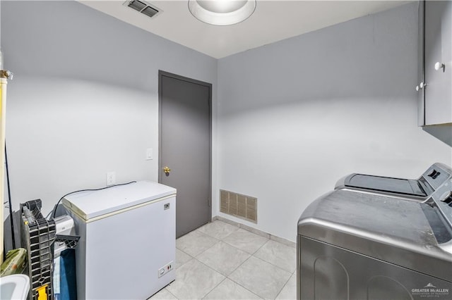 18064 Garrett Rd, Harlingen, TX 78552 - laundry area with washing machine and clothes dryer, cabinet space, and light tile patterned flooring