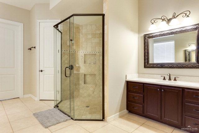 bathroom featuring tile patterned flooring, vanity, and a shower with door