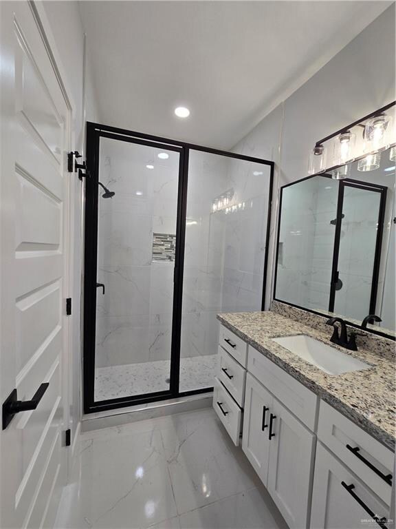 bathroom featuring vanity and a shower with shower door