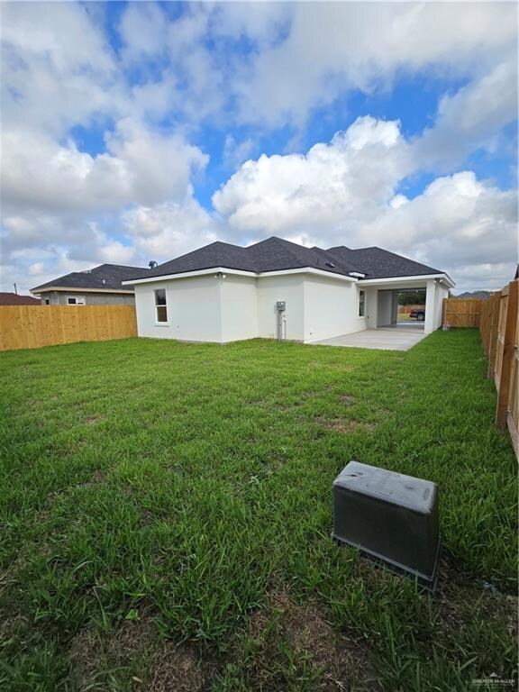 rear view of property with a patio area and a yard