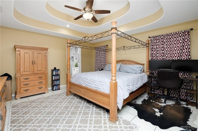 bedroom featuring a raised ceiling, ceiling fan, and light tile patterned floors