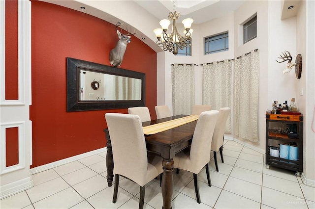 dining area with tile patterned floors and an inviting chandelier