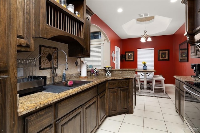 kitchen with sink, backsplash, a chandelier, decorative light fixtures, and stainless steel electric range