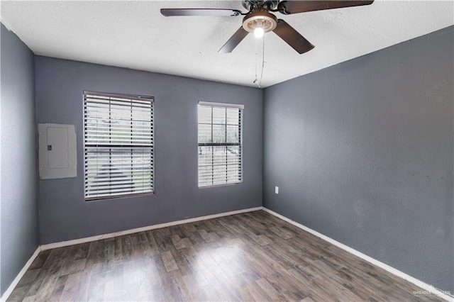 unfurnished room with electric panel, dark hardwood / wood-style floors, and ceiling fan