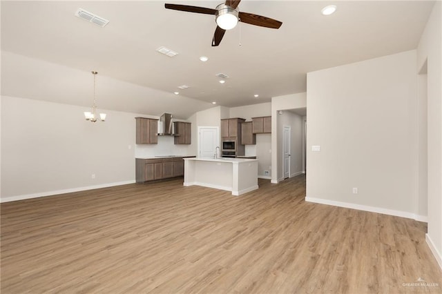 unfurnished living room featuring light wood-style floors, visible vents, baseboards, and ceiling fan with notable chandelier