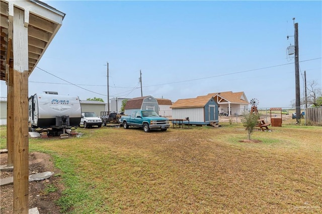 view of yard featuring an outbuilding, a storage unit, and fence