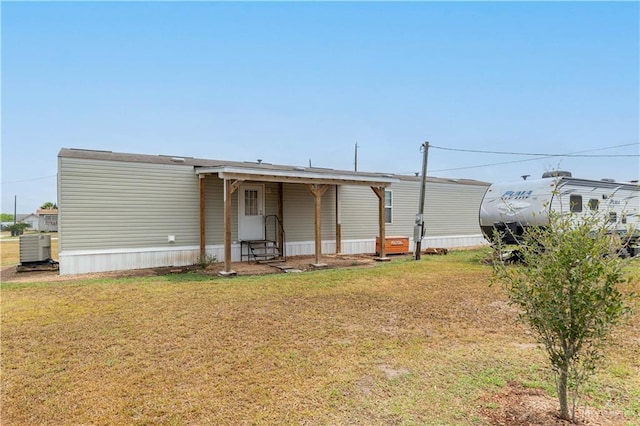 back of house featuring central AC unit, entry steps, and a yard