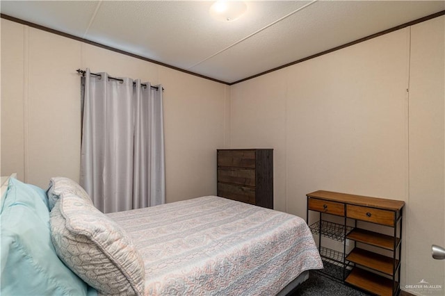 carpeted bedroom featuring a decorative wall and ornamental molding