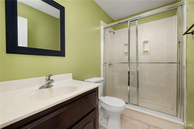 bathroom with tile patterned flooring, vanity, toilet, and a shower with door