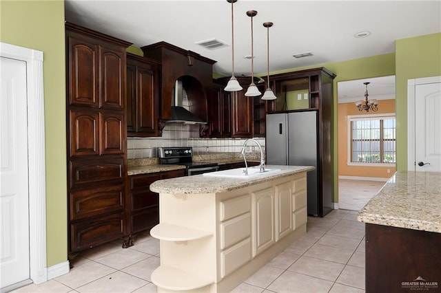 kitchen with sink, black range with electric cooktop, a notable chandelier, cream cabinetry, and a kitchen island with sink