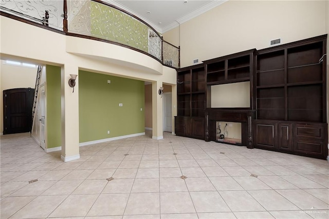 unfurnished living room with a towering ceiling, crown molding, and light tile patterned floors