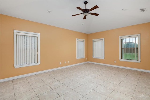 tiled spare room with vaulted ceiling and ceiling fan