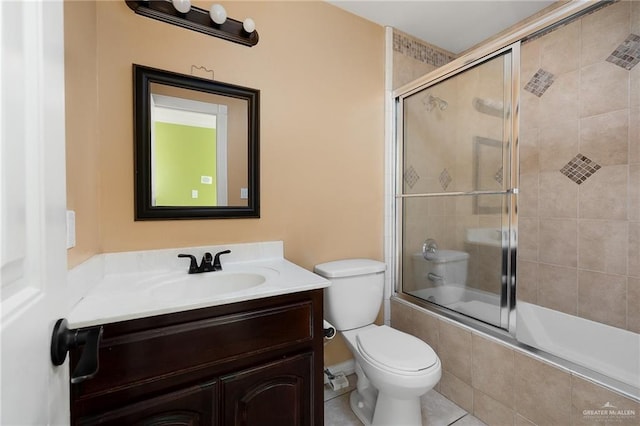 full bathroom featuring tile patterned flooring, vanity, toilet, and combined bath / shower with glass door